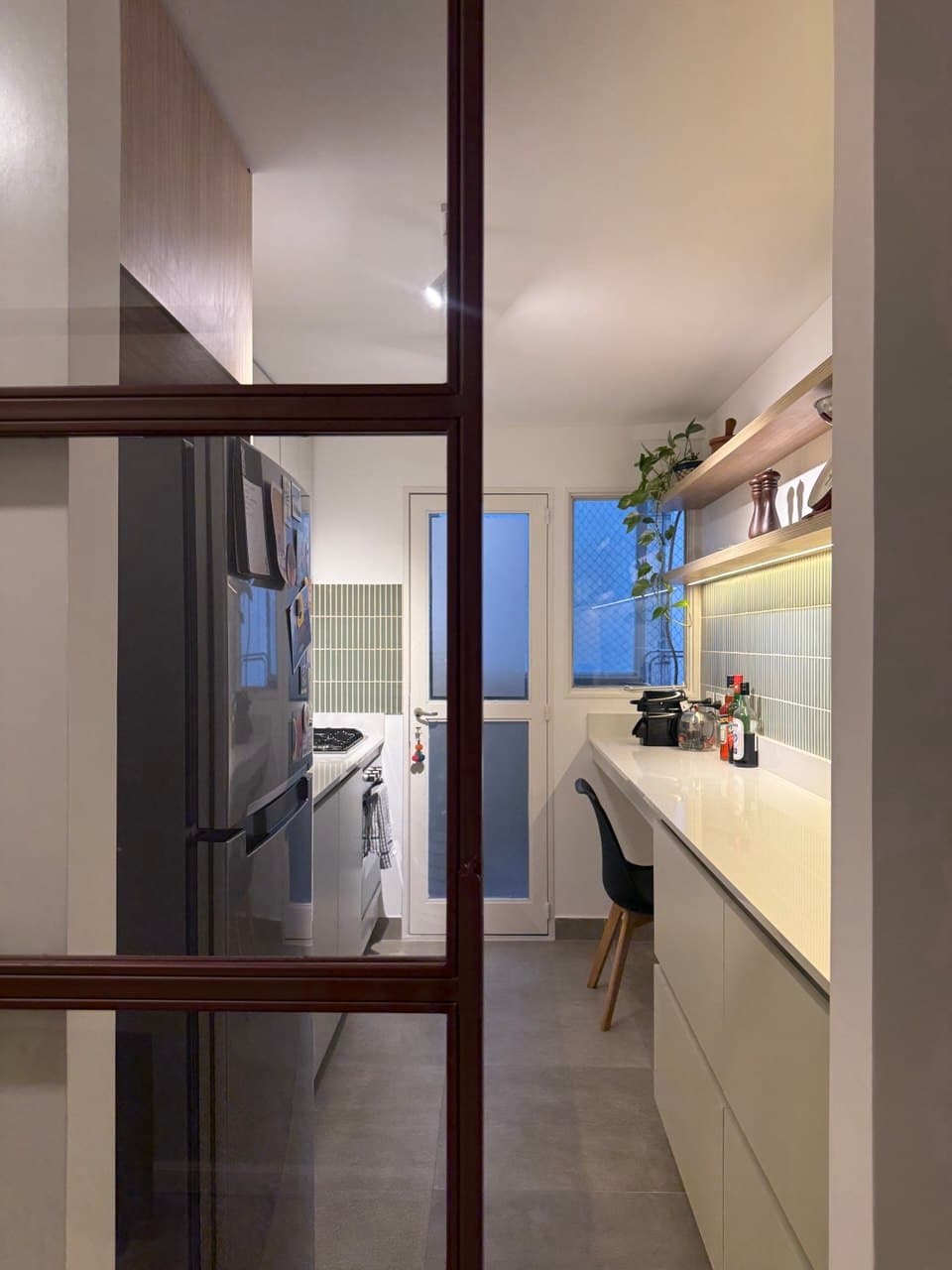 Cocina terminada, vista a través de una puerta vidriada con marco de madera