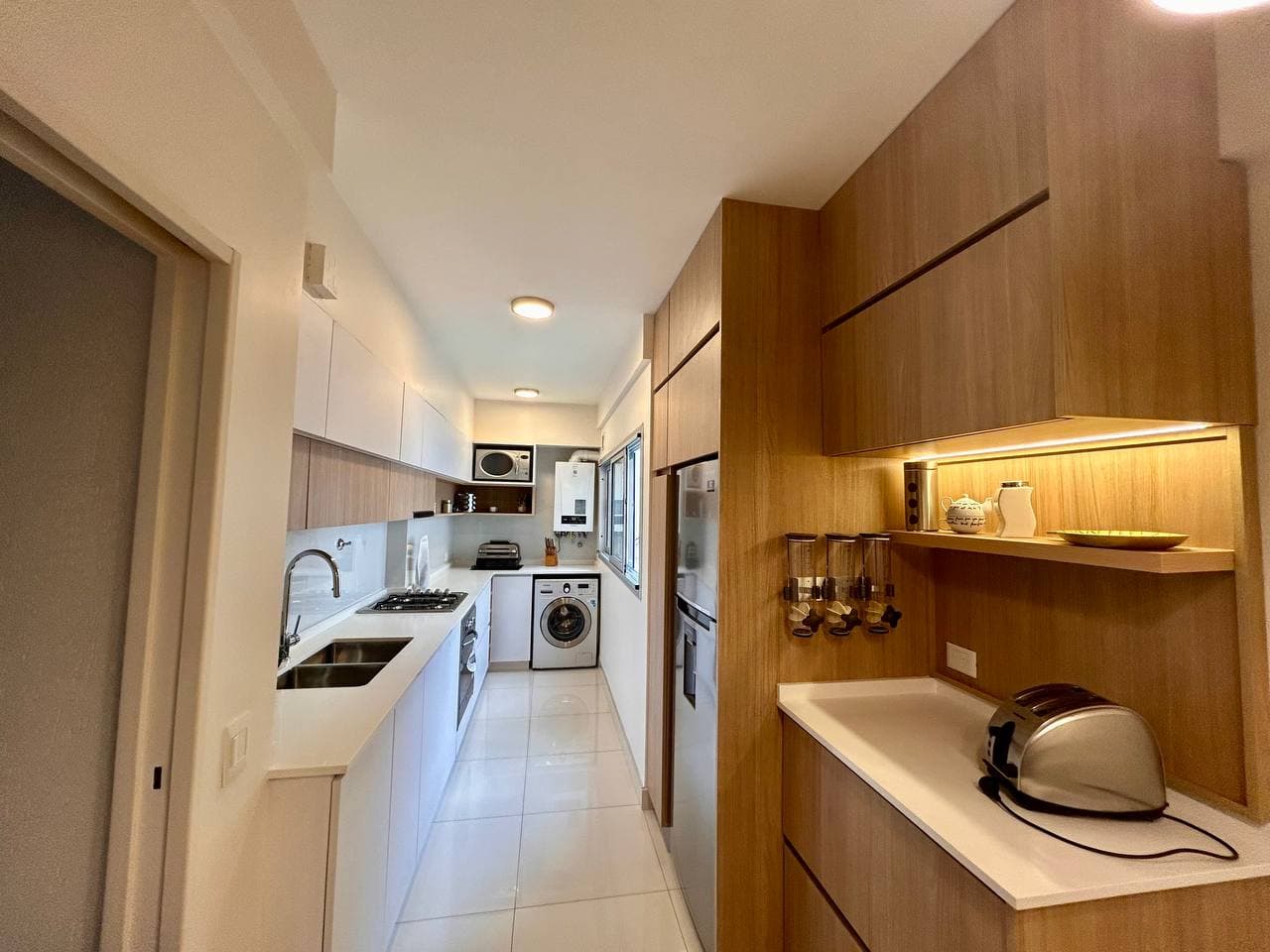 Cocina en tonos blancos y madera, vista en galería